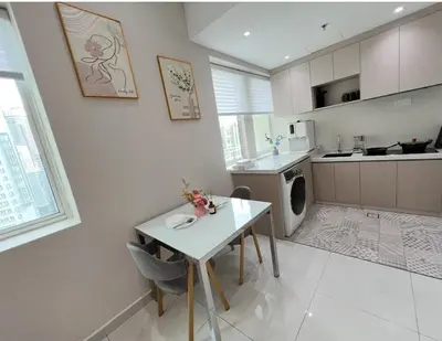a kitchen with a white table and a table and chairs at Parkview Serviced Apartment in Kuala Lumpur