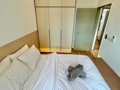 a stuffed elephant laying on a white bed at 3BR KL Sentral L27 Modern Vintage Views in Kuala Lumpur