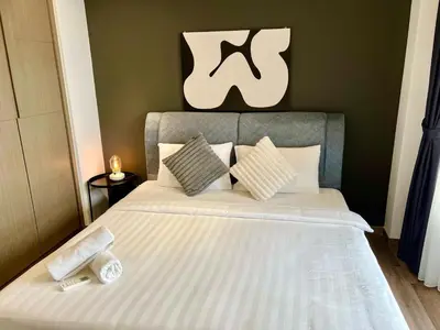 a bed with white sheets and pillows on it at Agile Landmark Suites by Kuala Lampur City in Kuala Lumpur