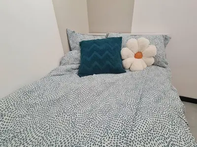a bed with a white flower on top of it at Small Studio Neu Suites Gleneagles Ampang KL in Kuala Lumpur
