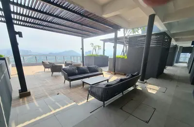 a patio with couches and tables and a view of the ocean at Little Studio Neu Suites near KLCC in Kuala Lumpur