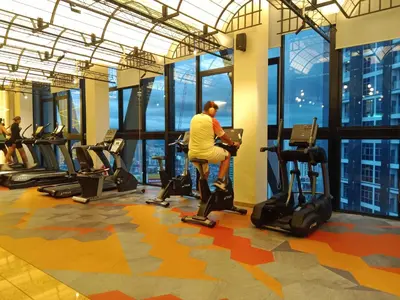 a man sitting on a exercise bike in a gym at Scarletz Suites Klcc Twin tower by Lucky in Kuala Lumpur