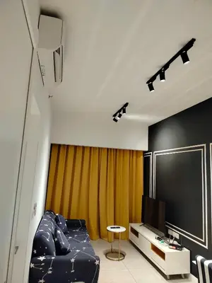a living room with a couch and a flat screen tv at skyscraper by cozy in Kuala Lumpur
