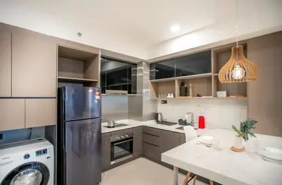 a kitchen with a stainless steel refrigerator and a table at Novo Ampang Residence Studio Close to KLCC and Gleneagles in Kuala Lumpur