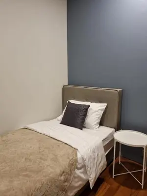 a bed with a pillow and a stool in a room at Scarletz Suites KLCC by ENBA in Kuala Lumpur
