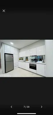 a kitchen with white cabinets and a black refrigerator at Scarletz Suites KLCC by ENBA in Kuala Lumpur