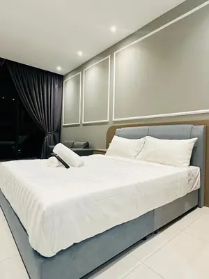 a bedroom with a large bed with white sheets at Majestic Residence KLCC By Homestay in Kuala Lumpur