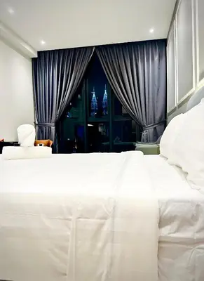 a large white bed in a room with a window at Majestic Residence KLCC By Homestay in Kuala Lumpur