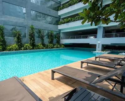 a swimming pool with two lounge chairs and a building at Comfort Stay Neusuite Jelatek in Kuala Lumpur