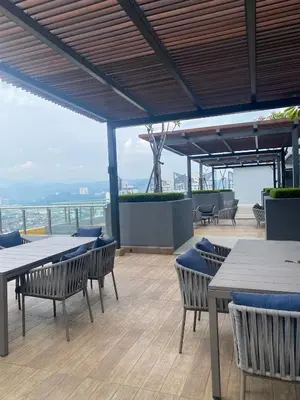 a restaurant with tables and chairs on a roof at Comfort Stay Neusuite Jelatek in Kuala Lumpur