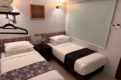 a room with two beds and a mirror at Lofts At Hang Kasturi Kuala Lumpur in Kuala Lumpur