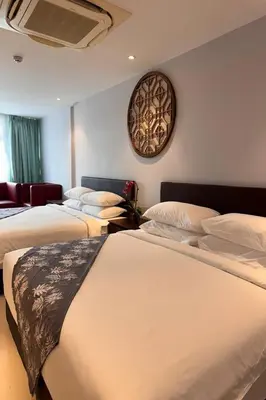 a bedroom with two beds and a clock on the wall at Lofts At Hang Kasturi Kuala Lumpur in Kuala Lumpur