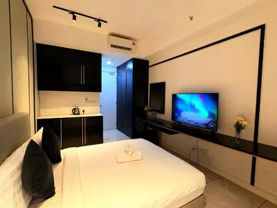 a bedroom with a white bed and a flat screen tv at The Axon Residence KLCC Suites Kuala Lumpur in Kuala Lumpur