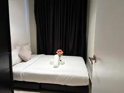 a small bed with a vase of flowers on it at The Axon Residence KLCC Suites Kuala Lumpur in Kuala Lumpur