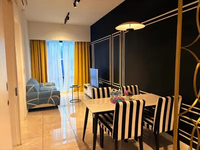 a living room with a table and chairs and a couch at The Axon Residence KLCC Suites Kuala Lumpur in Kuala Lumpur