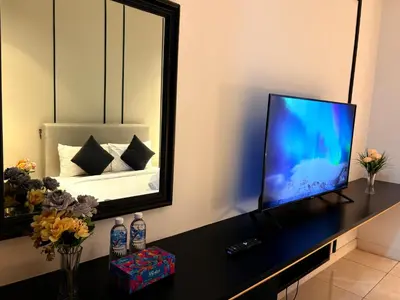 a television sitting on a table in front of a mirror at The Axon Residence KLCC Suites Kuala Lumpur in Kuala Lumpur