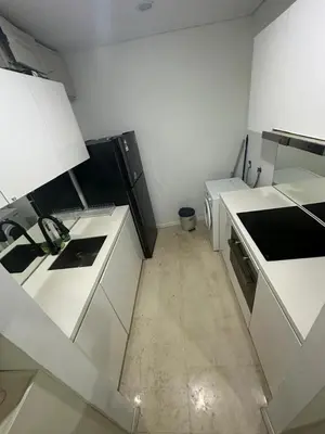 a kitchen with white counters and white appliances at Vortex suites klcc 8pax with City views in Kuala Lumpur