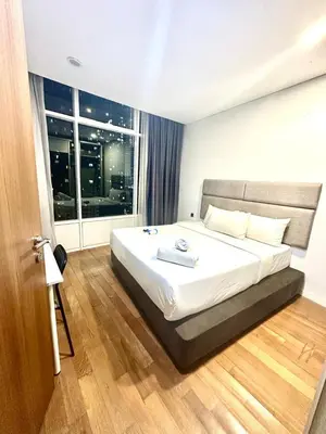 a bedroom with a bed and a large window at Vortex suites klcc 8pax with City views in Kuala Lumpur