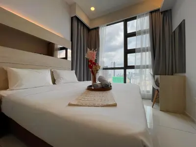 a large white bed with a vase of flowers on it at The Robertson Bukit Bintang by TALKS COLLECTION in Kuala Lumpur