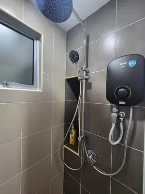 a shower in a bathroom with a television on the wall at RC Balqis Homestay in Kuala Lumpur