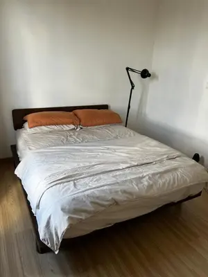 a bedroom with a bed with white sheets and orange pillows at Tuan Residency in Kuala Lumpur