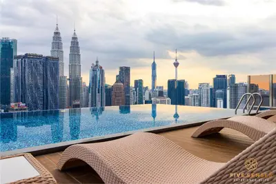 a swimming pool on the roof of a building with a city at Armani Residence Kuala Lumpur in Kuala Lumpur