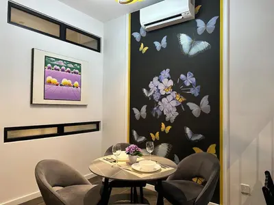a dining room with a table and chairs and butterflies on the wall at Scarletz Suites KLCC Studio in Kuala Lumpur