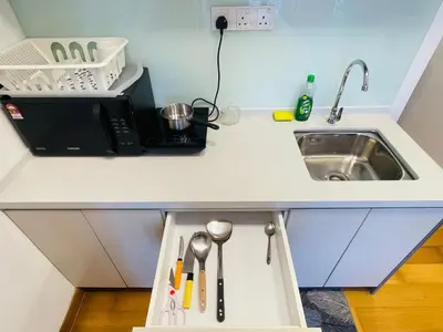 a kitchen counter with a sink and a microwave at The Luxe Infinity Skypool By Tasu Homes in Kuala Lumpur