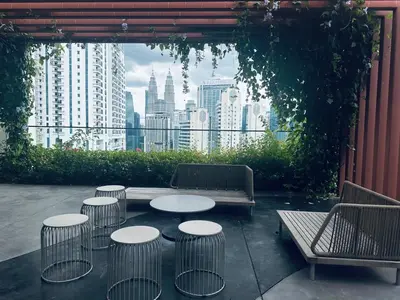 a patio with tables and chairs and a view of a city at Majestic Residence KLCC By Alfa in Kuala Lumpur