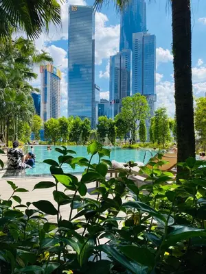 a fountain in a park with a city in the background at Agile Sky Pavilion Homestay Bukit Bintang KL in Kuala Lumpur