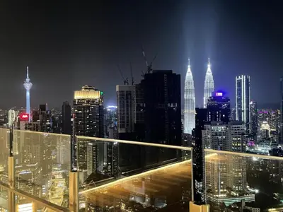 a view of a city skyline at night at Agile Sky Pavilion Homestay Bukit Bintang KL in Kuala Lumpur