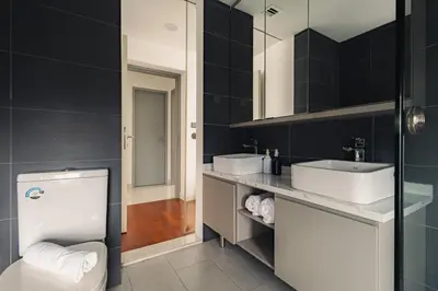 a bathroom with a white toilet and two sinks at Novo Ampang 2 Bedrooms KLCC view in Kuala Lumpur