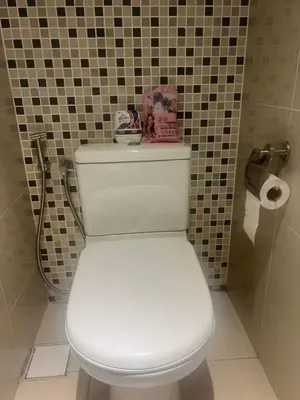 a white toilet in a bathroom with a tiled wall at D Majestic hosted by Super Tang in Kuala Lumpur