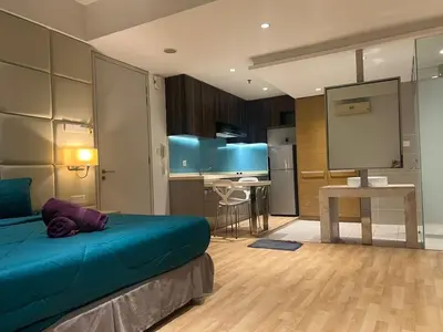 a bedroom with a blue bed and a kitchen at D Majestic hosted by Super kk in Kuala Lumpur
