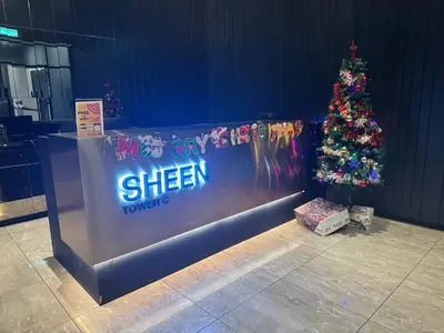 a christmas tree in front of a wall with a sign at Trion Dream house KL City in Kuala Lumpur
