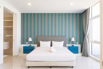 a bedroom with a large white bed and blue walls at The Platinum Kuala Lumpur by MAHA in Kuala Lumpur
