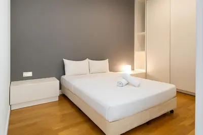 a bedroom with a large white bed with a light on it at The Platinum Kuala Lumpur by MAHA in Kuala Lumpur