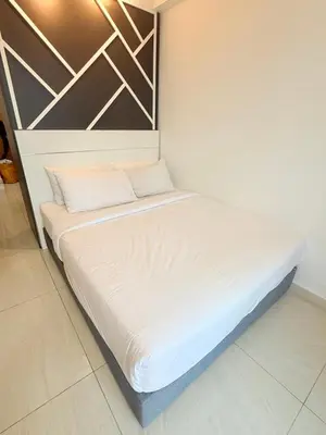 a bed in a room with white sheets at Colony Suites KL by Sopping Centre in Kuala Lumpur