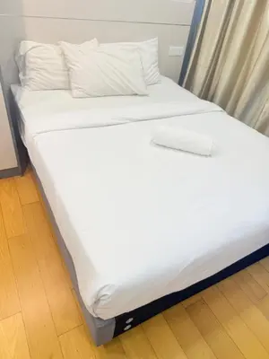 a large white bed with white sheets and pillows at Colony Suites KL by Sopping Centre in Kuala Lumpur