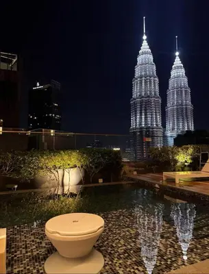 a toilet sitting in a pool with two tall buildings at luxury One Bedroom KLCC in Kuala Lumpur