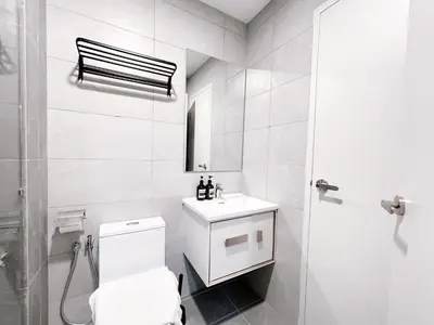 a white bathroom with a toilet and a sink at Majestic Residence by Manhattan Group in Kuala Lumpur