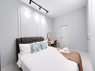 a white bedroom with a large bed and a table at Majestic Residence by Manhattan Group in Kuala Lumpur