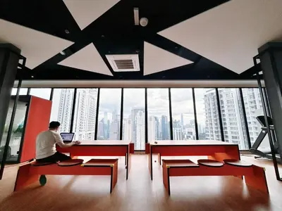 a man sitting at a desk with a laptop in a building at Majestic Residence by Manhattan Group in Kuala Lumpur