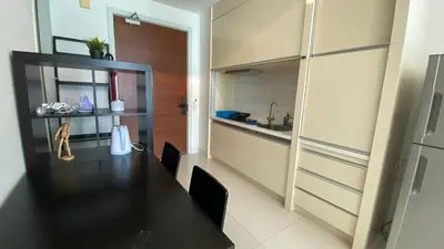 a dining room with a black table and a kitchen at 3-10mins to klcc -pavilion -premium studio 2-4pax in Kuala Lumpur