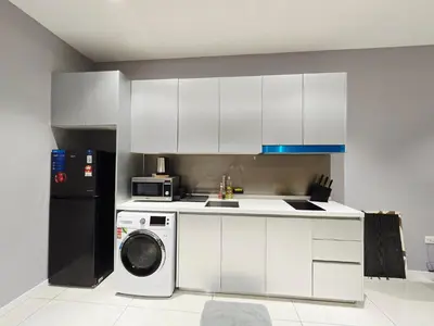 a kitchen with white cabinets and a washing machine at Quill Residence Queen House in Kuala Lumpur