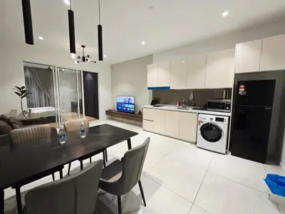 a kitchen and living room with a table and a dining room at Quill Residence Queen House in Kuala Lumpur