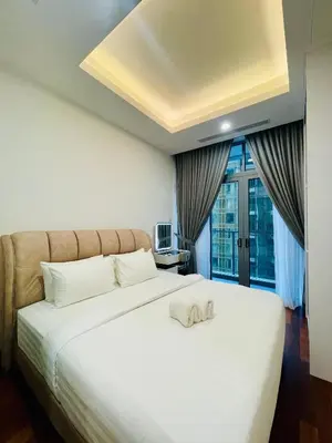 a bedroom with a white bed with a towel on it at Royce Residence KLCC by ABM Unique in Kuala Lumpur