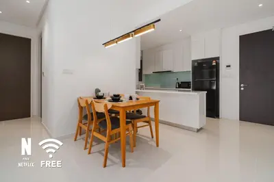 a kitchen with a wooden table and some chairs at Elegant 2BR Residence at MET 1 in Kuala Lumpur