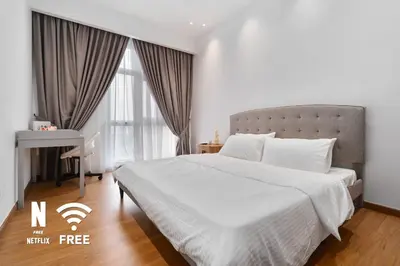 a bedroom with a white bed and a desk at Elegant 2BR Residence at MET 1 in Kuala Lumpur