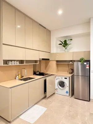 a kitchen with white cabinets and a washing machine at Lucentia Suties Rooftop pool by Lalaport KL in Kuala Lumpur